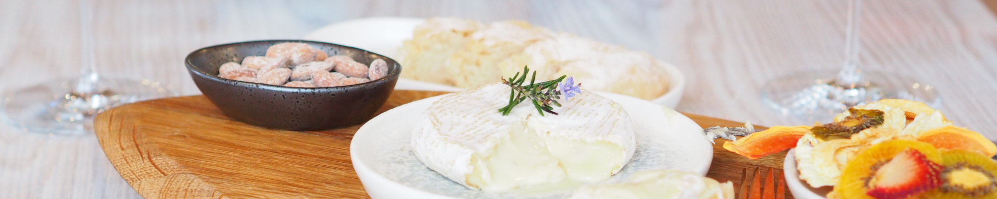 a plate of cheese with a sprig of rosemary