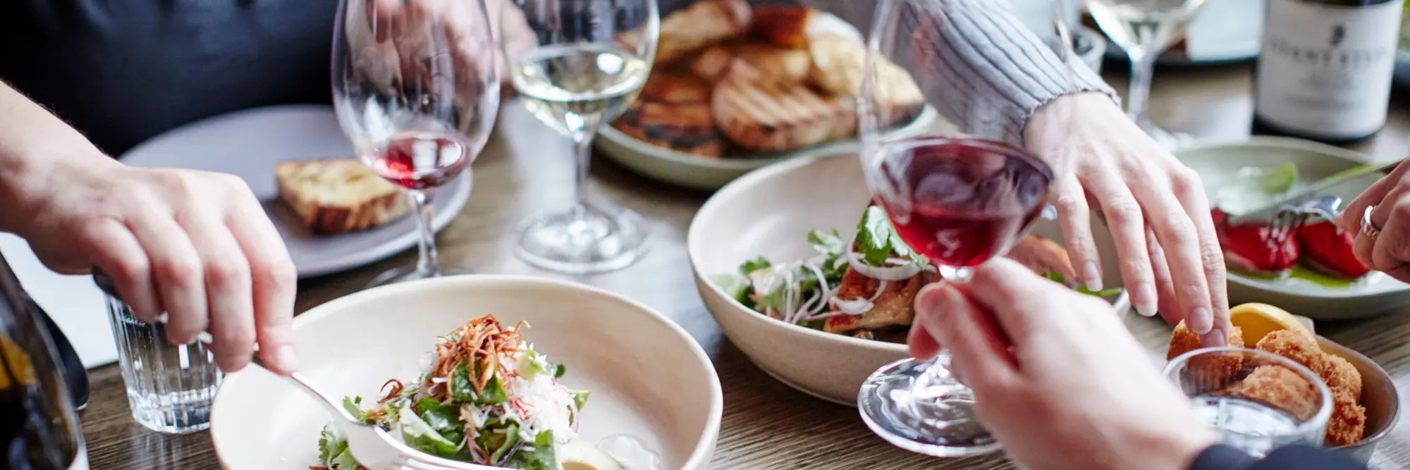 a group of people holding wine glasses and eating food