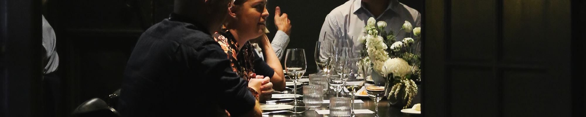 a group of people sitting at a table with wine glasses