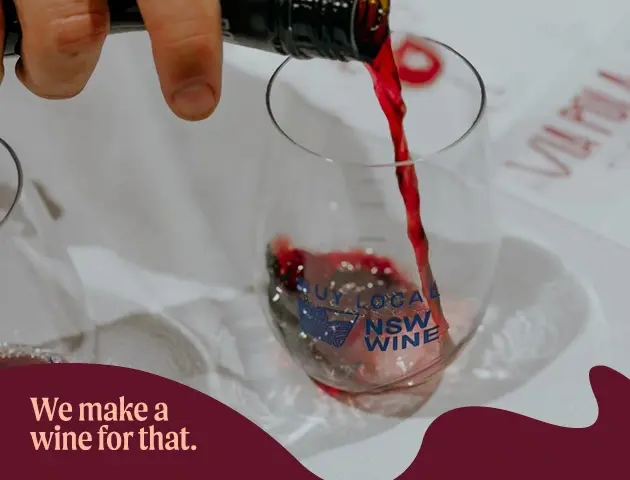 a hand pouring red wine into a glass
