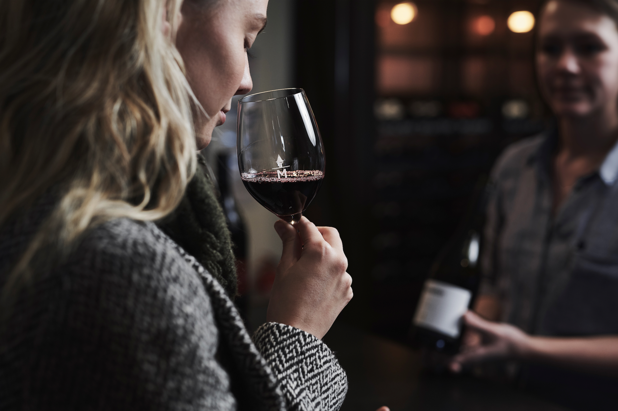 a woman smelling a glass of wine