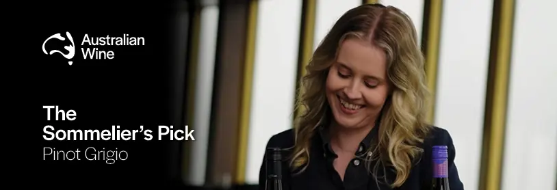 a woman smiling with a bottle of wine
