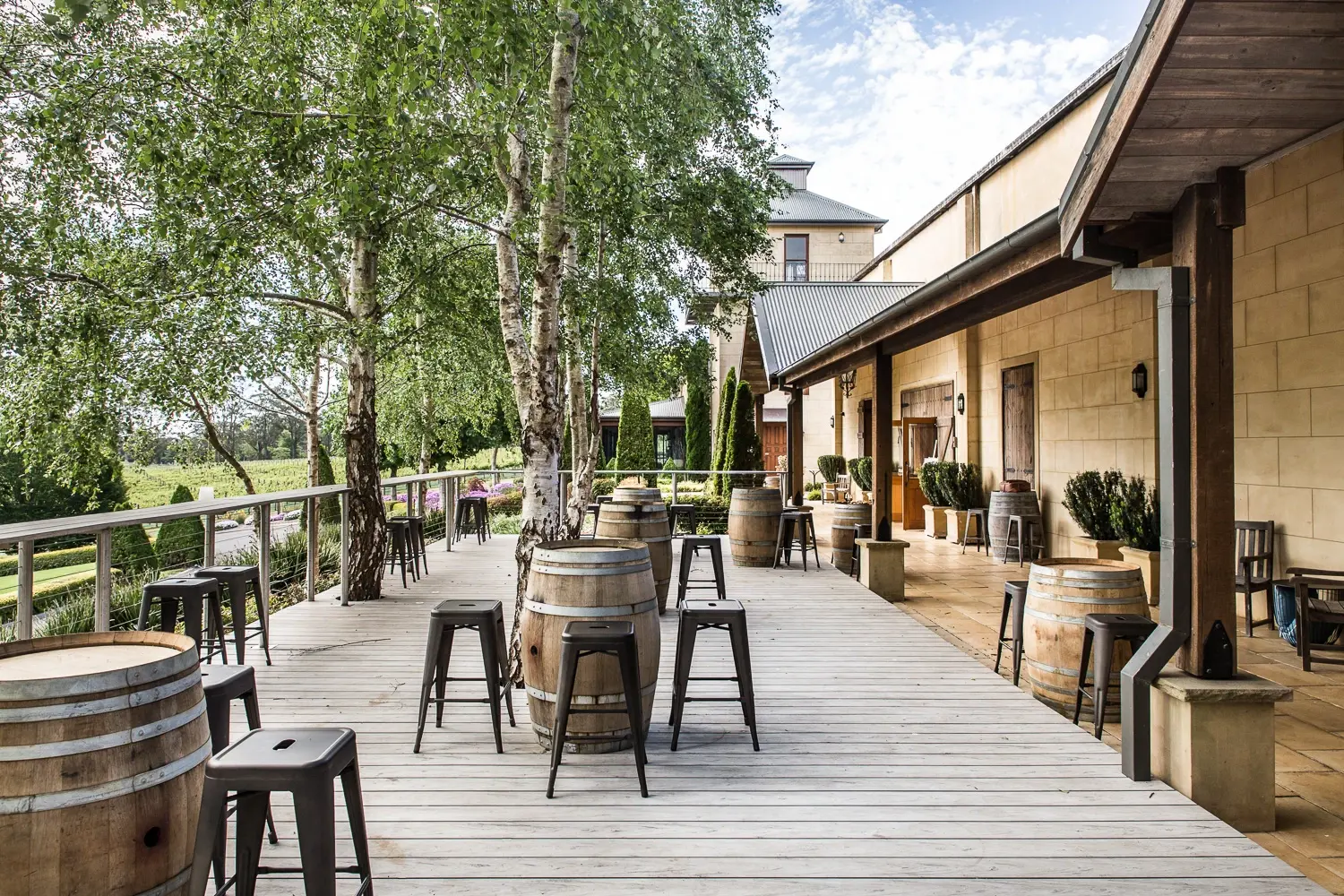 a wooden deck with chairs and barrels on it