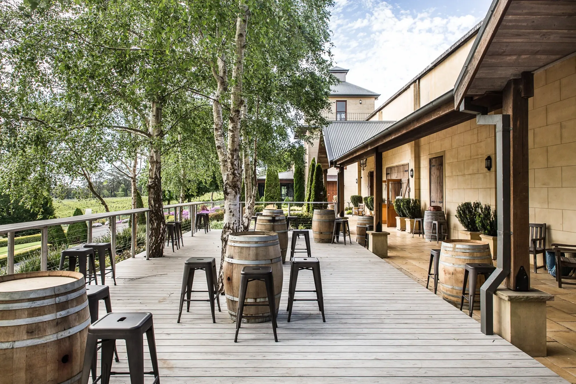a wooden deck with chairs and barrels on it