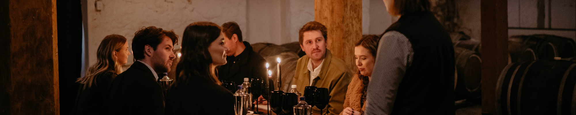 a group of people sitting at a table with candles