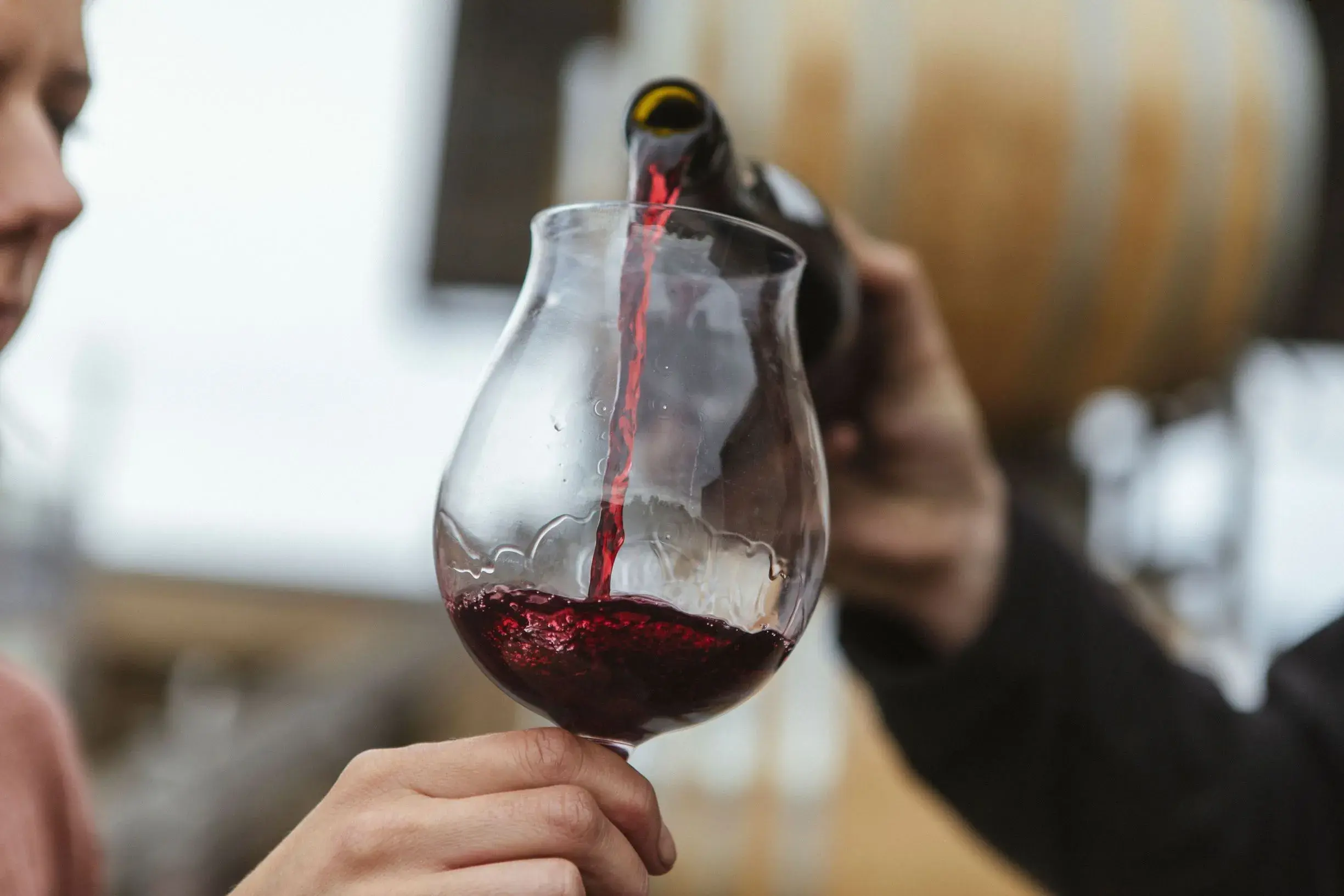 a person pouring a glass of wine