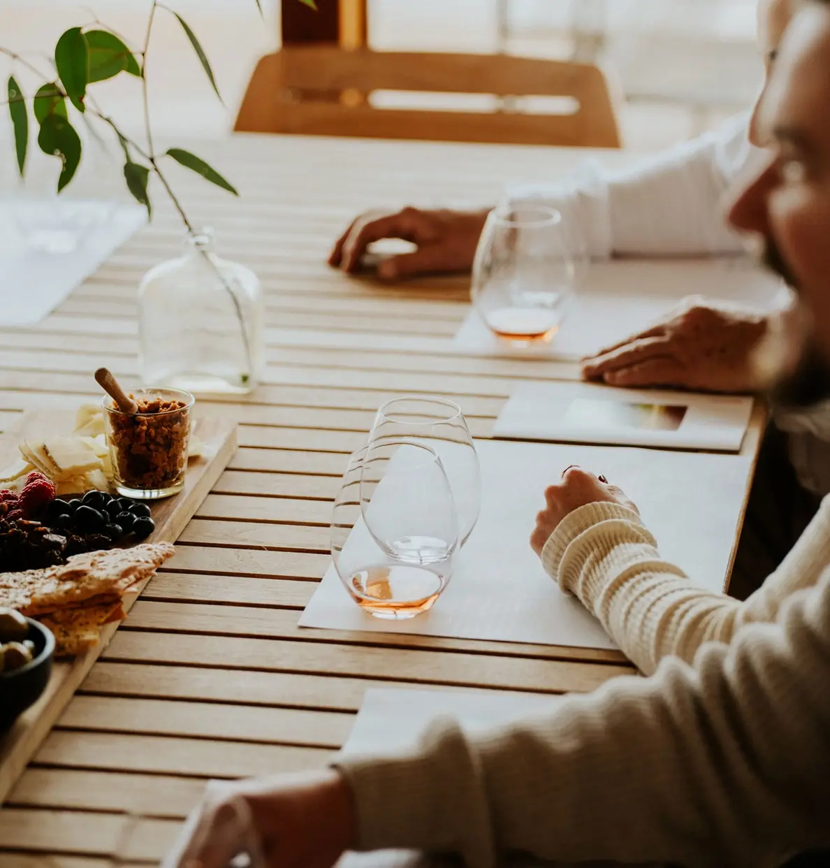 a man and woman sitting at a table with wine glasses