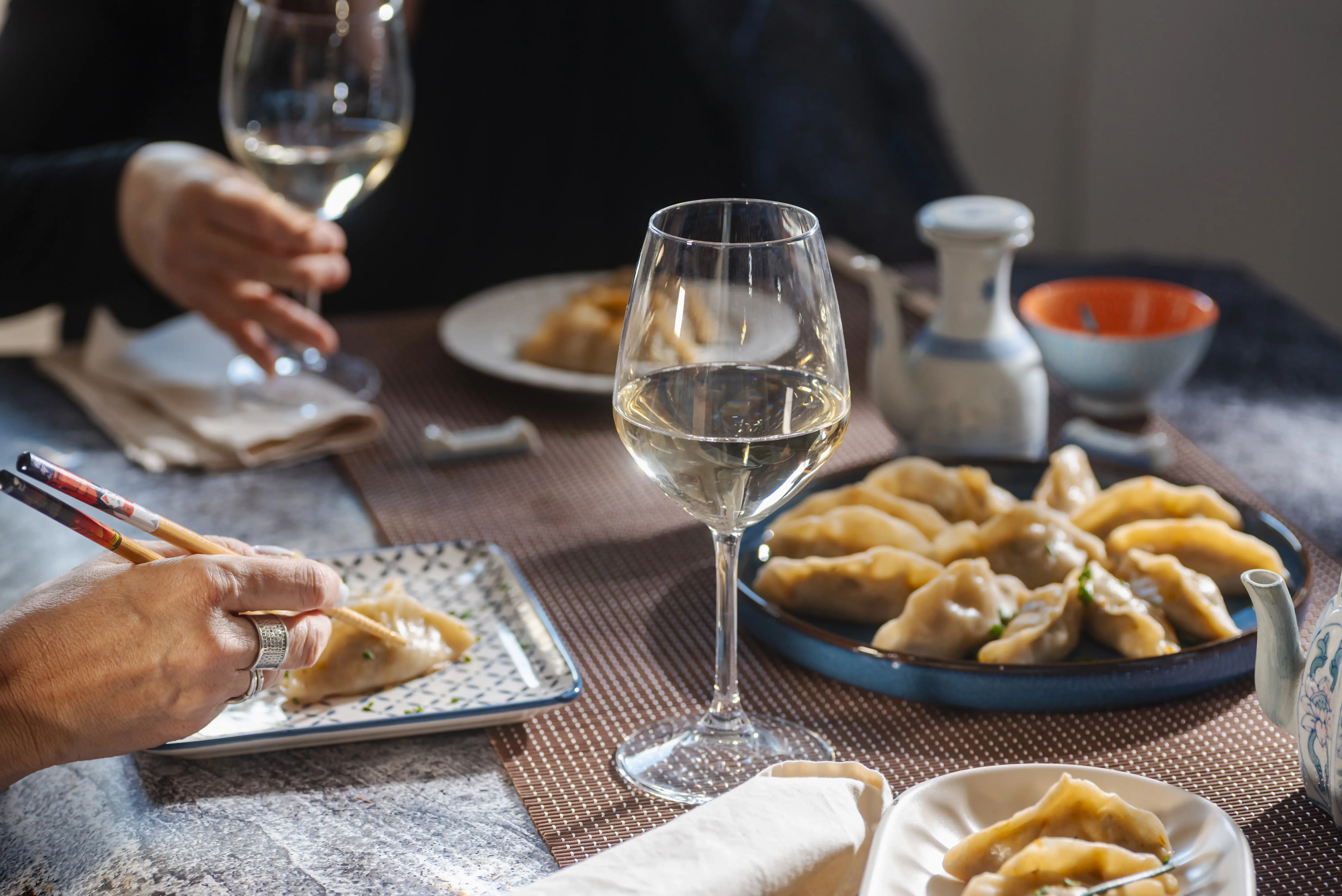 a glass of wine on a table with plates of food