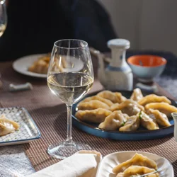 a glass of wine on a table with plates of food