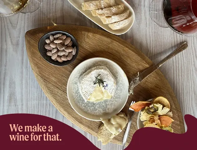 a plate of cheese and snacks on a wooden tray