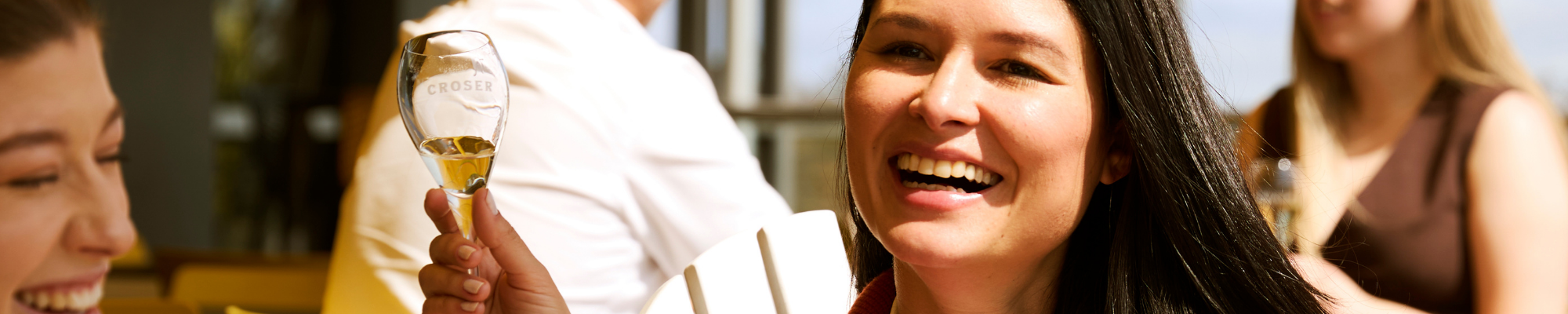 a woman smiling with a white cup in her hand