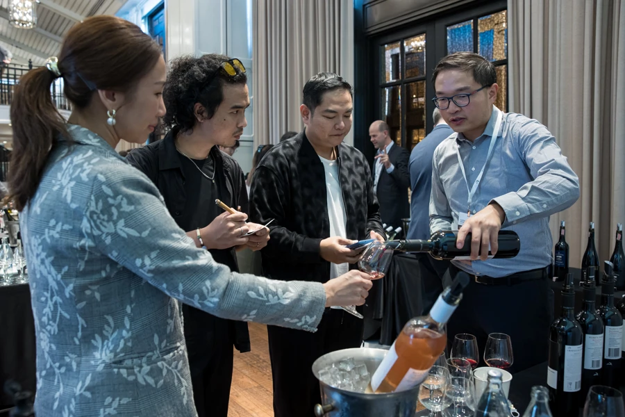 a group of people pouring wine into a bucket