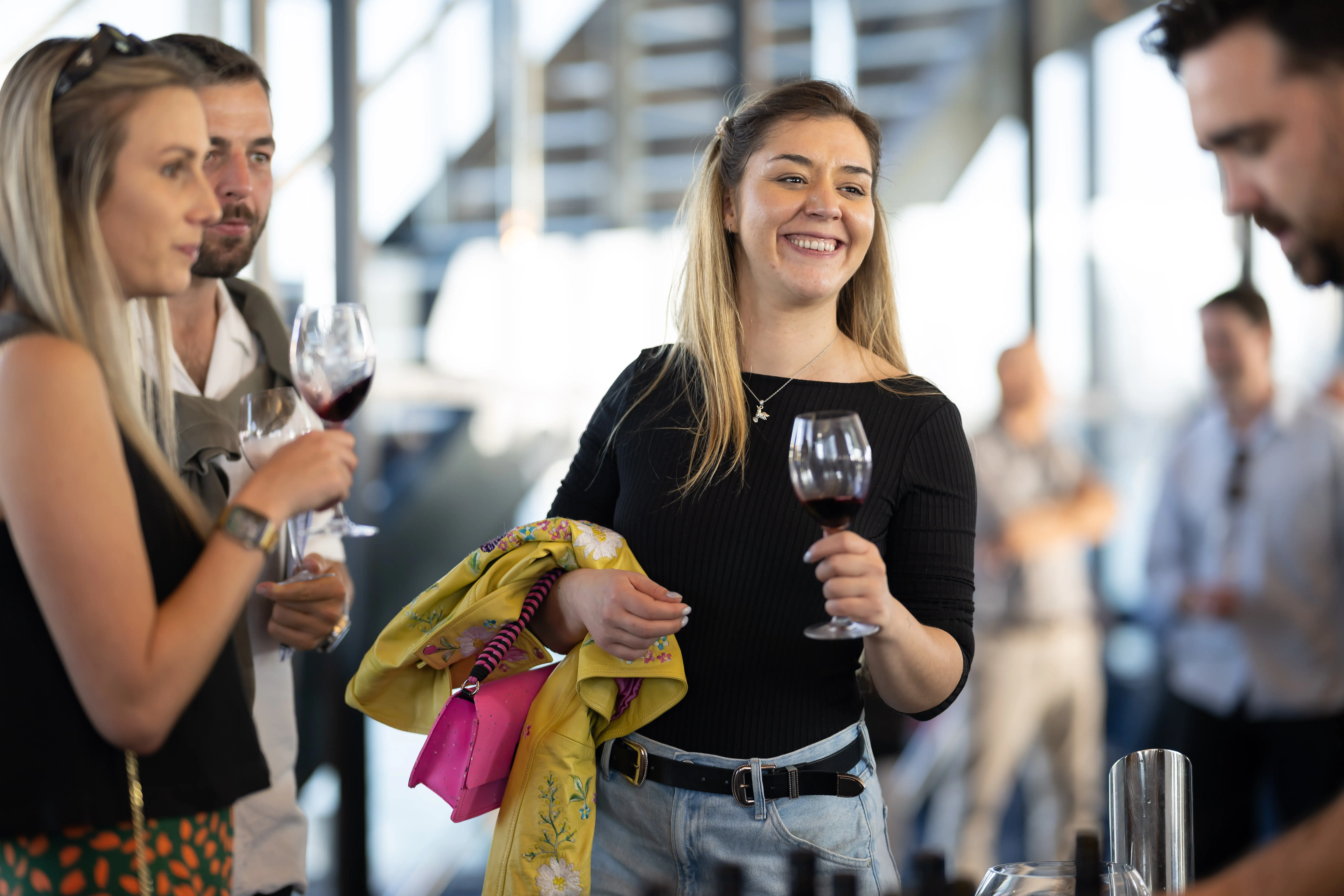 a woman holding wine glasses and smiling