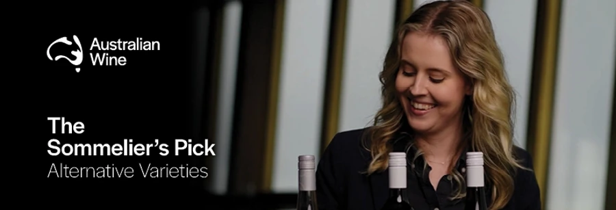 a woman smiling at a bottle of wine