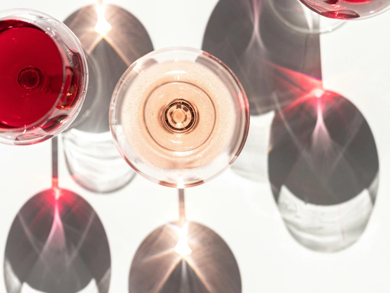 a group of wine glasses with red liquid