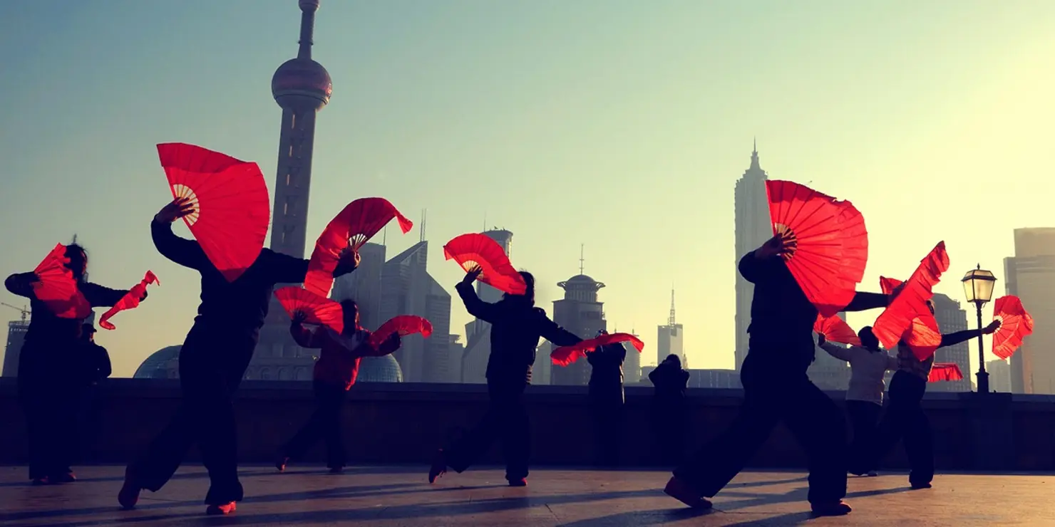 a group of people dancing with red fabric
