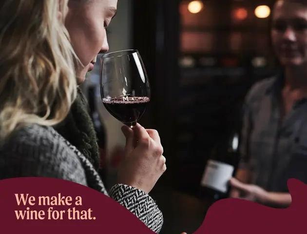 a woman smelling a glass of wine
